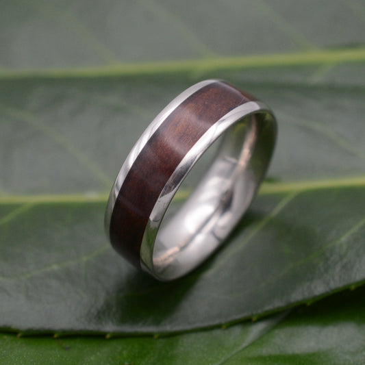 a wedding ring with a wooden inlay on a leaf