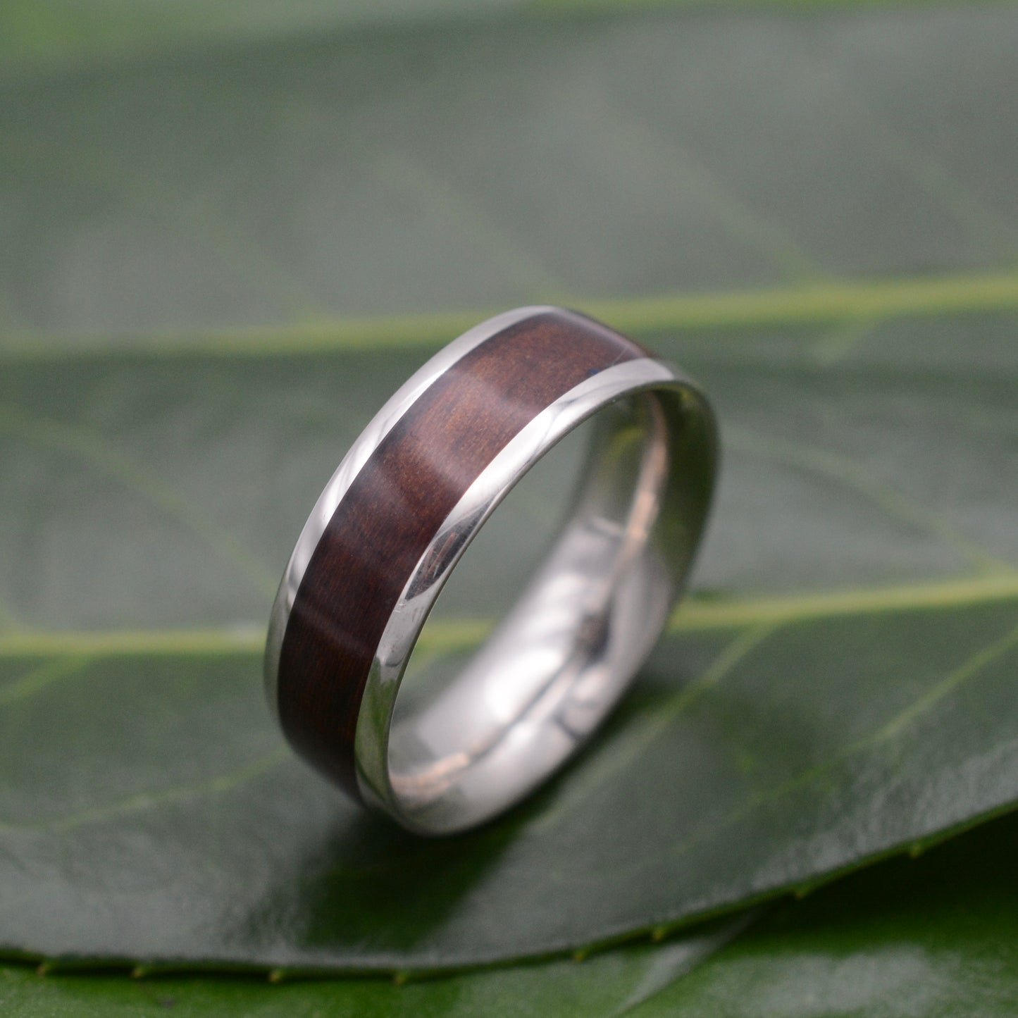 a wedding ring with a wooden inlay on a leaf