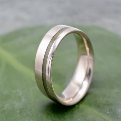 a wedding ring sitting on top of a green leaf