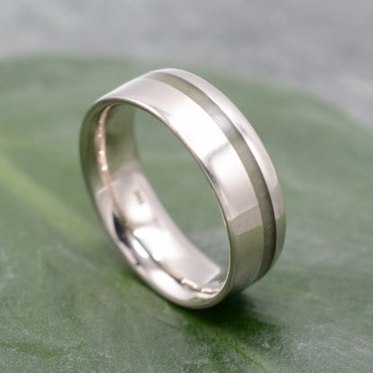 a wedding ring sitting on top of a green leaf