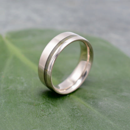 a wedding ring sitting on top of a green leaf
