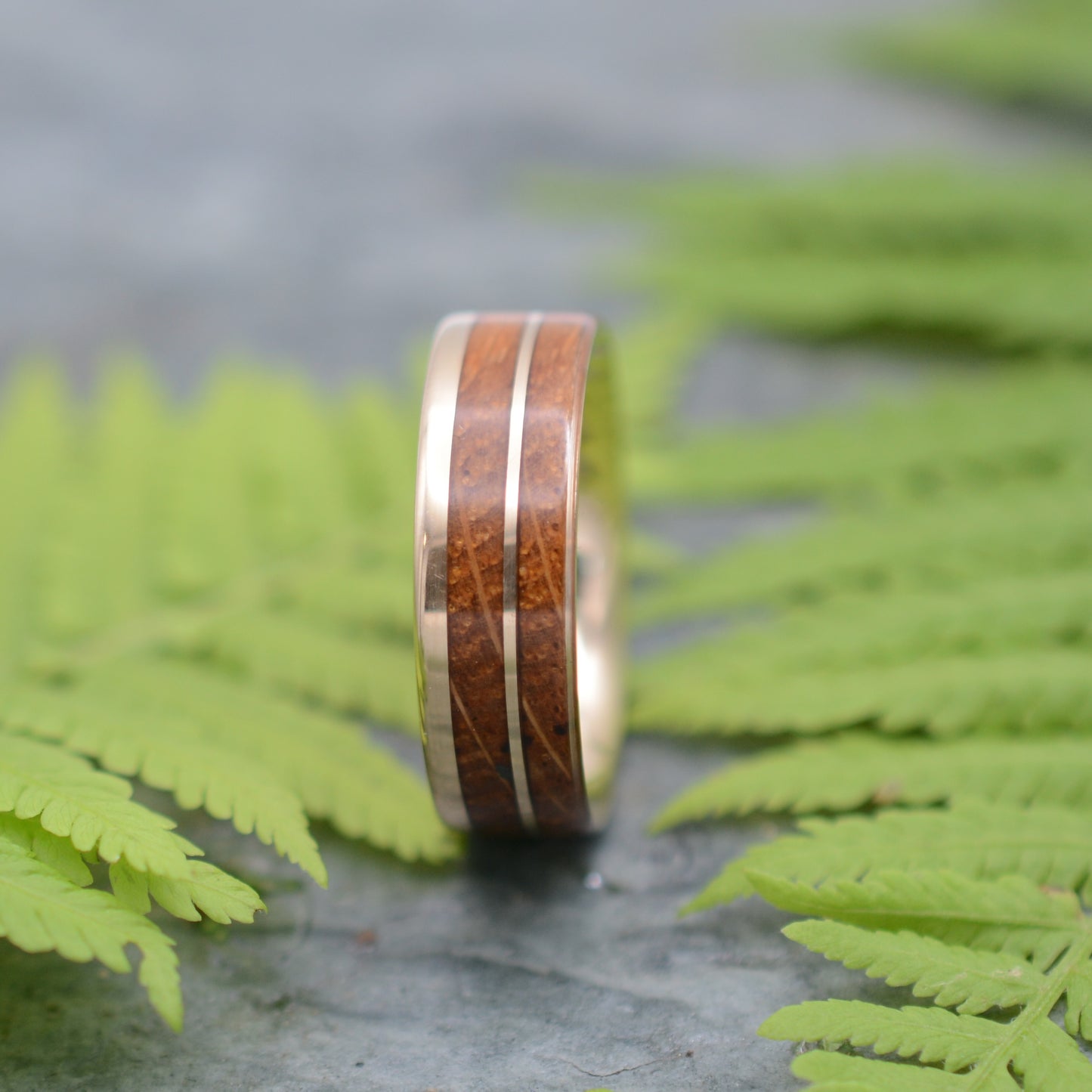 Front view of the Un Lado Asi wood wedding ring design with bourbon barrel and 14k yellow gold.