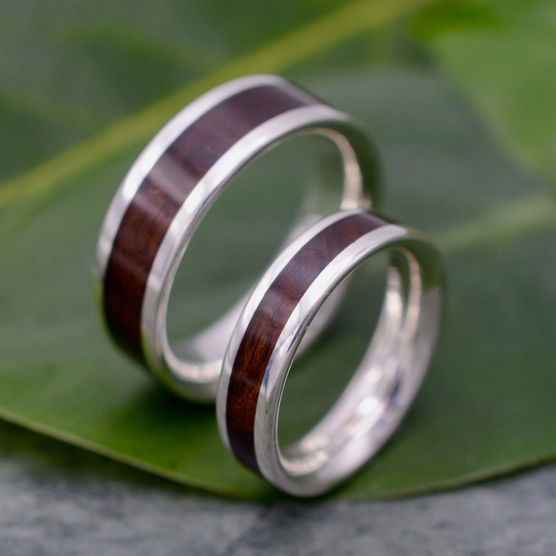 a couple of rings sitting on top of a leaf