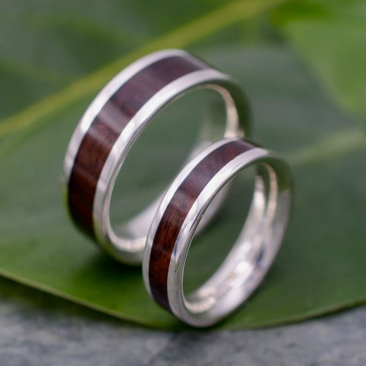 a couple of rings sitting on top of a leaf