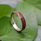 a silver ring with a red wood in it