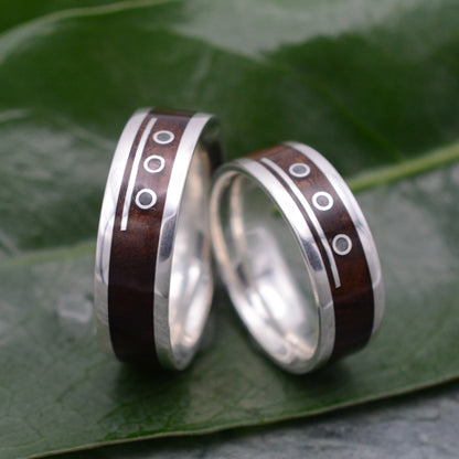 a couple of rings sitting on top of a leaf