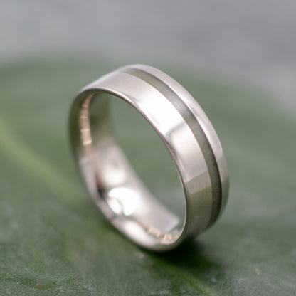 a wedding ring with a thin band on a green surface