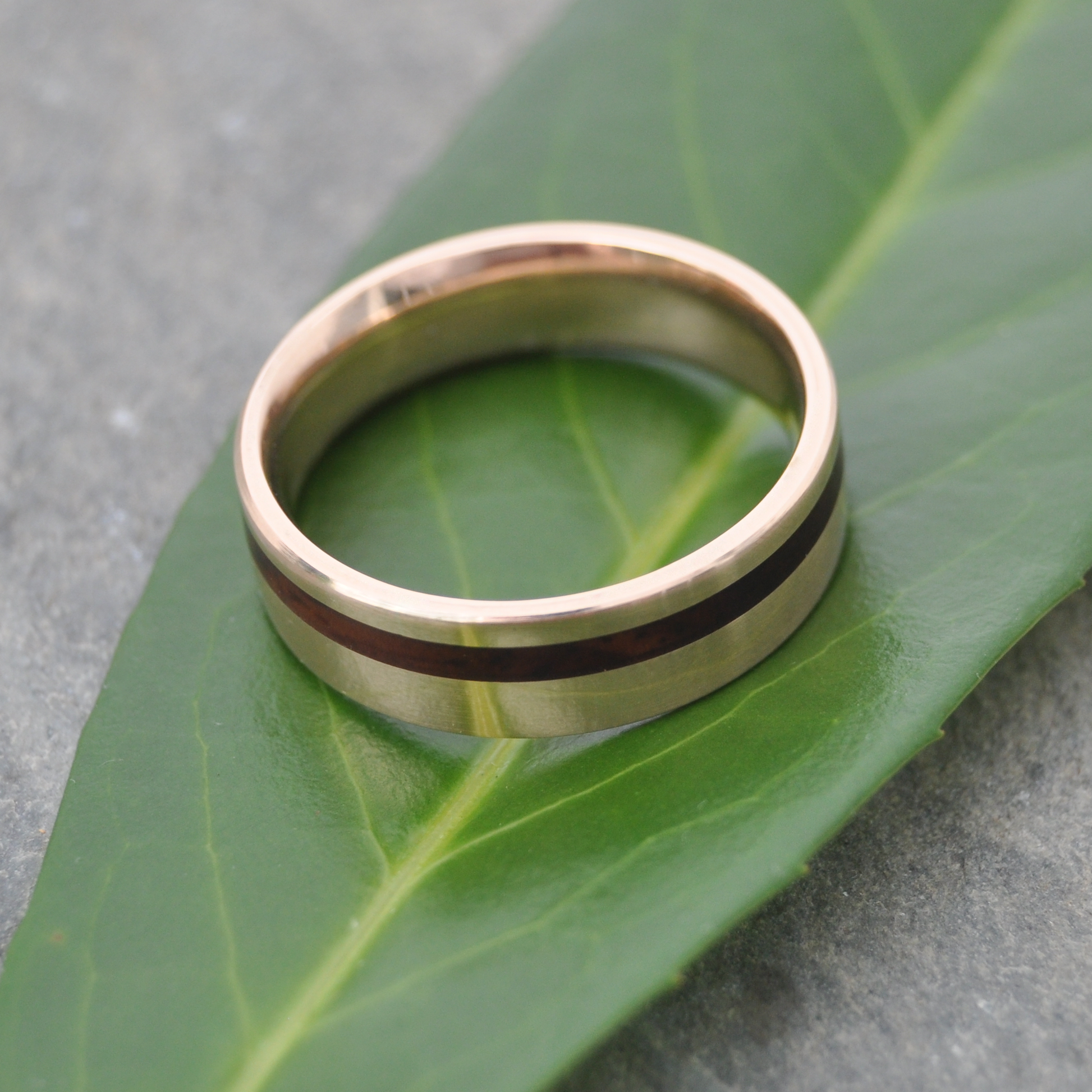 Side view of comfort fit yellow gold wood wedding band with cocobolo