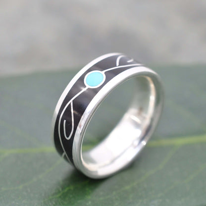 Close-up of turquoise vine inlay and black coyol seed in silver ring