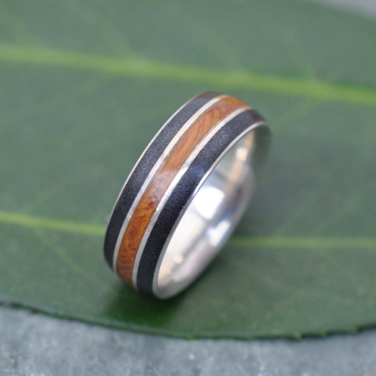 Sustainable wedding band with reclaimed bourbon barrel and titanium sand