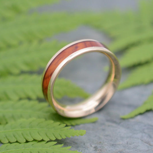 a gold ring with a wood in the middle