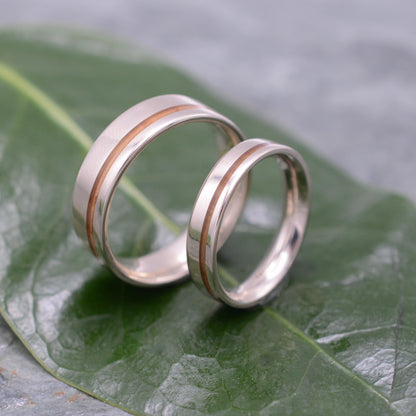 two wedding rings sitting on top of a green leaf
