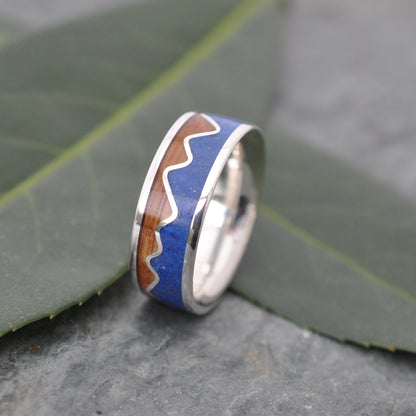 Lapis Lazuli Mountain Ring, Bourbon Barrel Wood and Sterling Silver on a slate background, showcasing unique craftsmanship.