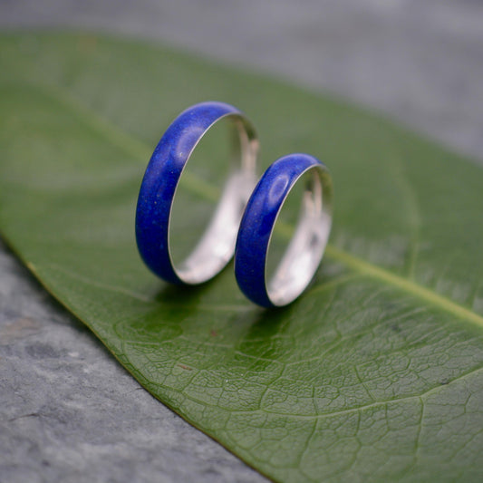 Two lapis lazuli silver wedding rings on green leaf, Siempre design