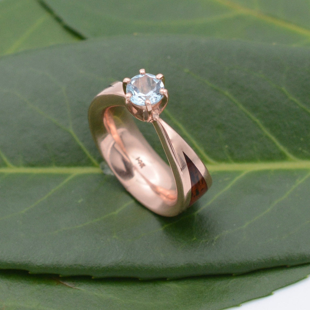 Aquamarine wood engagement ring with Kentucky walnut and recycled rose gold tapered band on natural background
