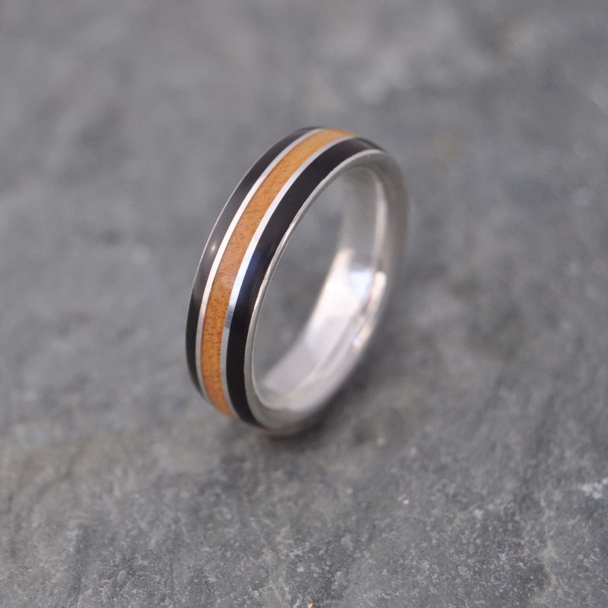 Sustainable silver and wood wedding band with black coyol and moran wood
