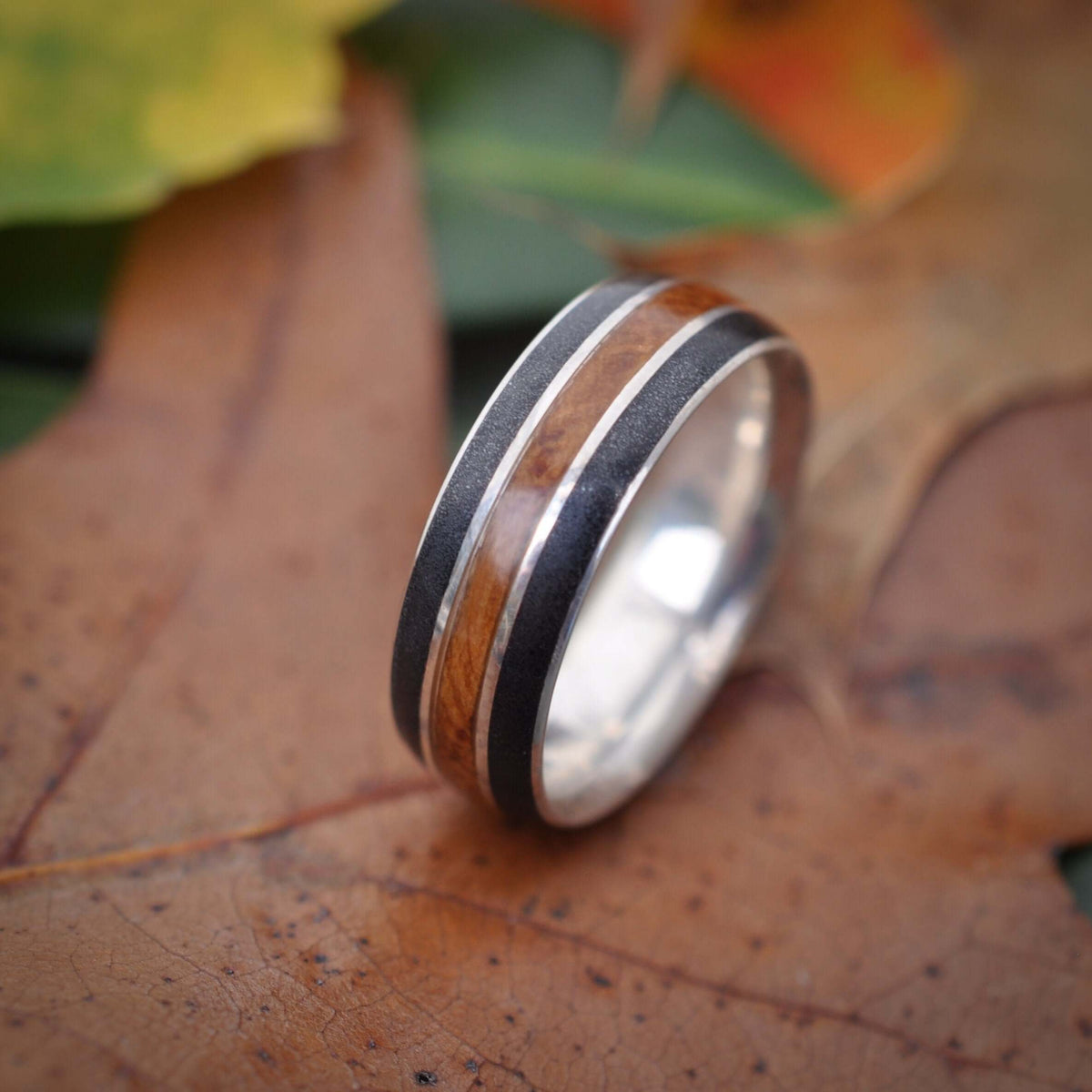 Reclaimed bourbon barrel wood wedding band with black titanium sand inlay
