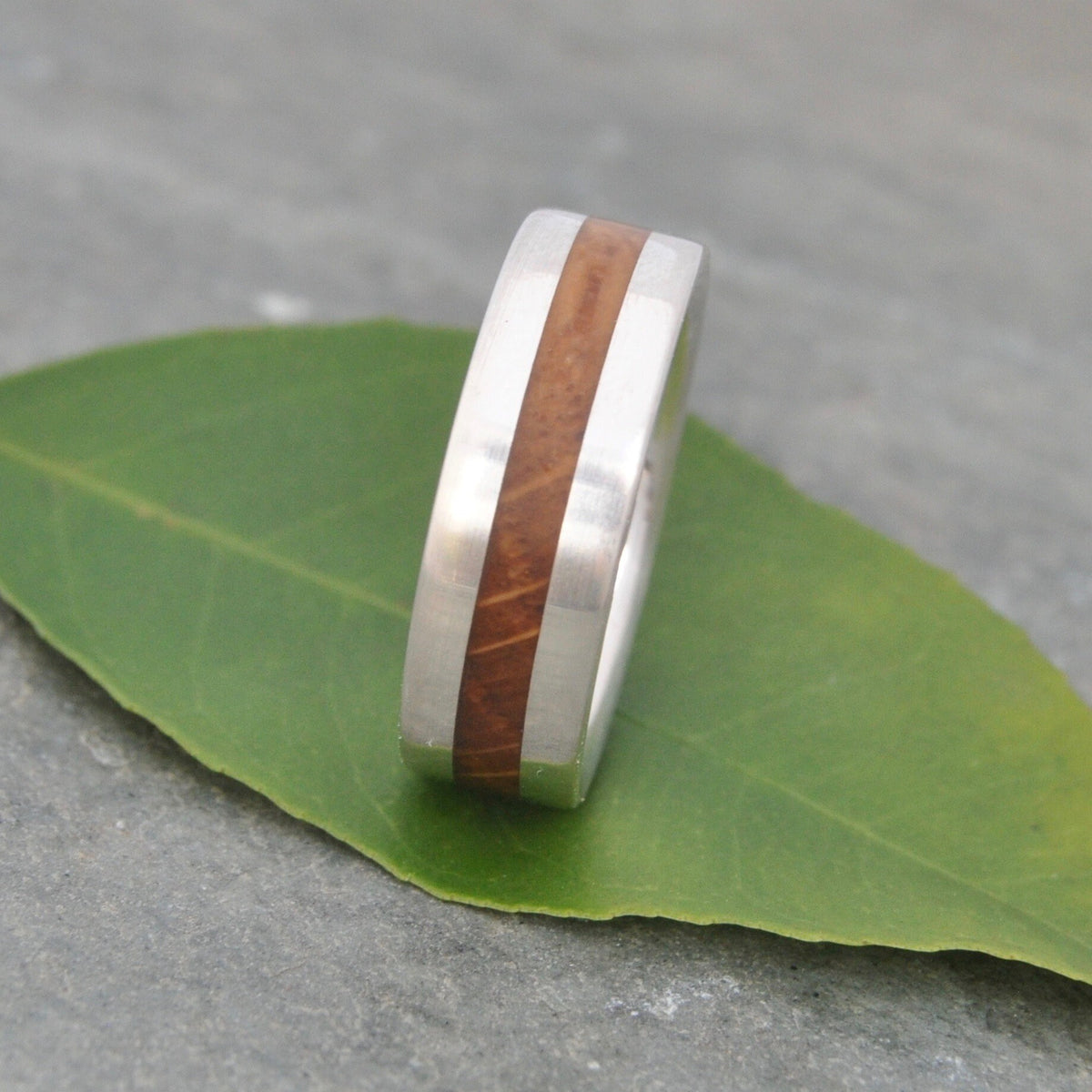 Close-up of reclaimed bourbon barrel wood grain in Centro silver ring