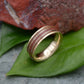 a gold ring sitting on top of a green leaf