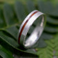 a wedding ring with a wooden inlay sits on a leaf