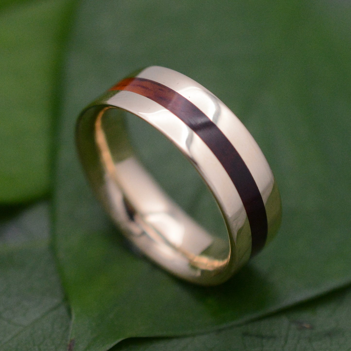 a gold ring with a red stripe on it