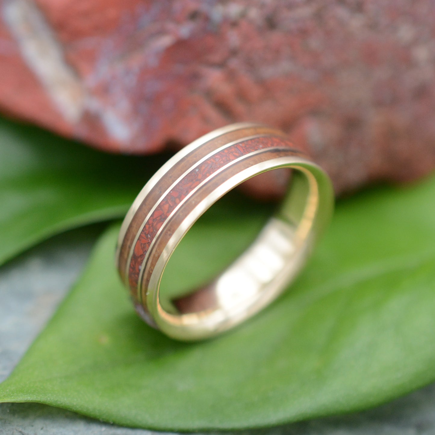 a gold ring sitting on top of a green leaf