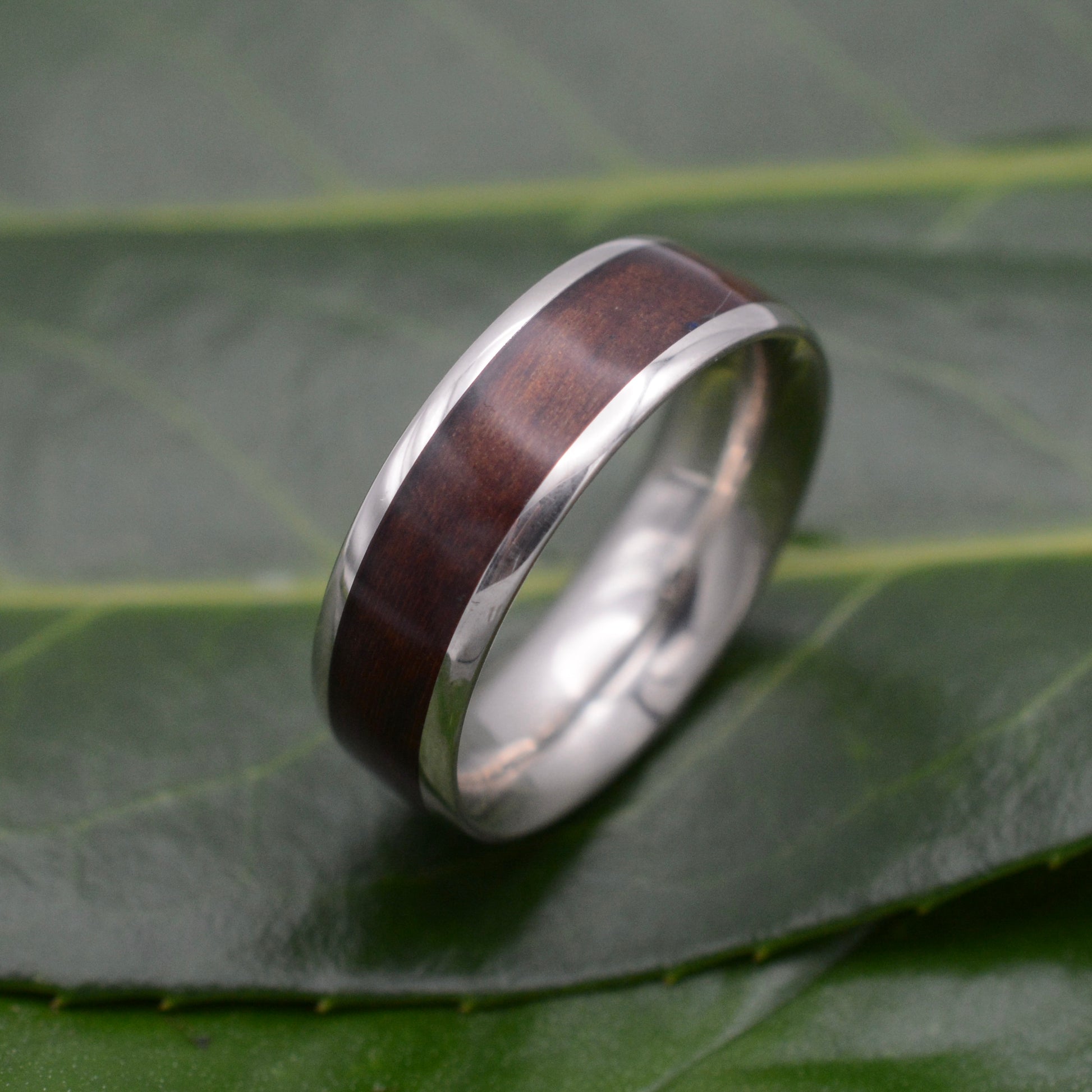 a wedding ring with a wooden inlay on a leaf