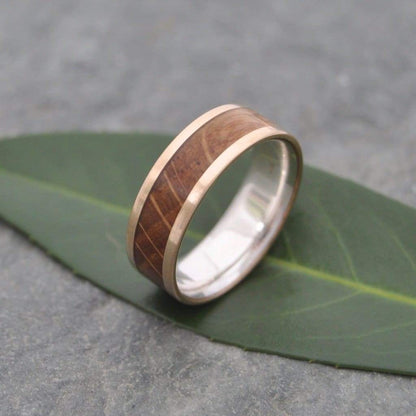 Close-up of bourbon barrel wood grain in Lados yellow gold and silver wedding band
