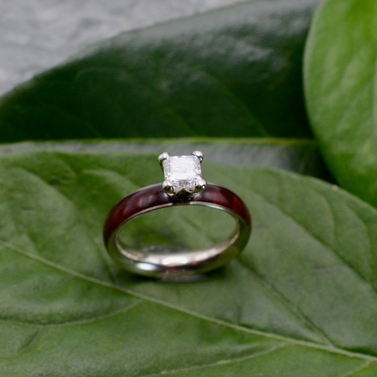 Princess cut diamond wood engagement ring with cocobolo wood band worn on hand