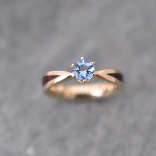 Custom wooden engagement ring with aquamarine solitaire and 14k yellow gold, cocobolo wood band, handcrafted by Naturaleza Organic Jewelry in Louisville Kentucky