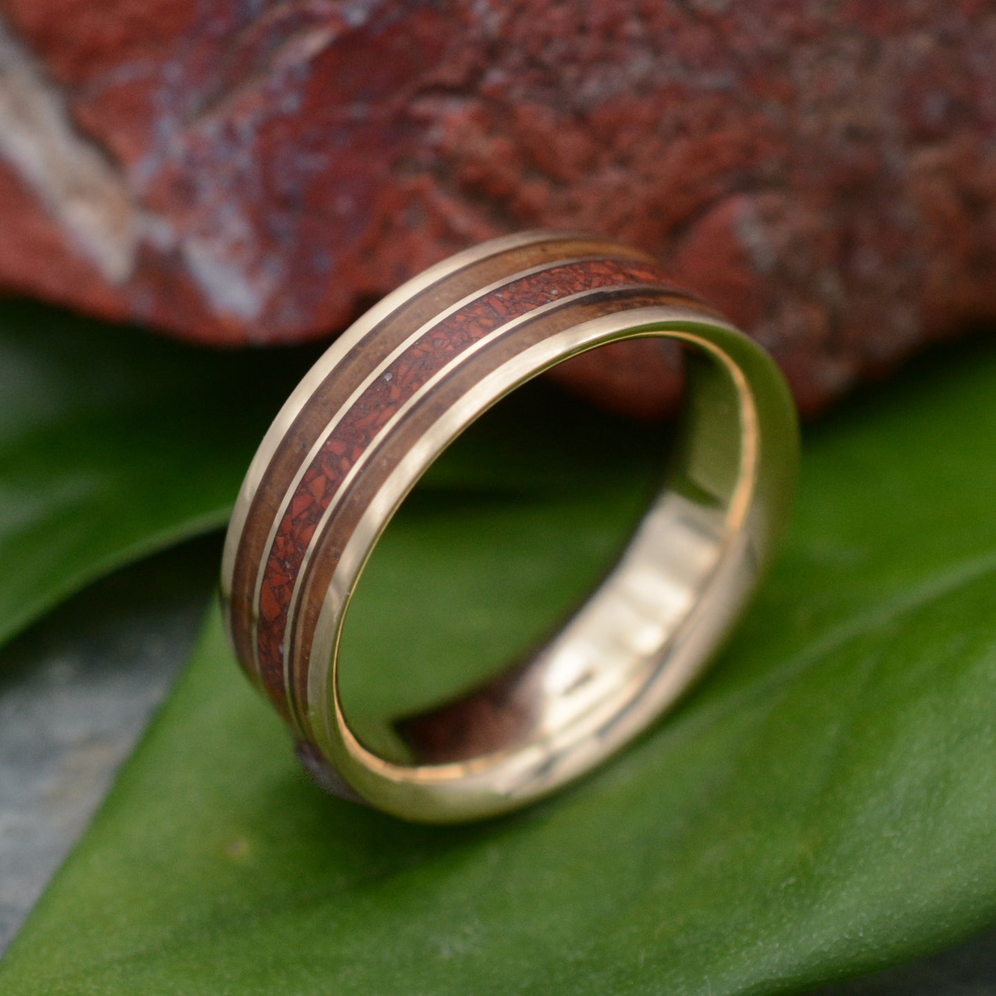 a gold wedding band with a wood inlay