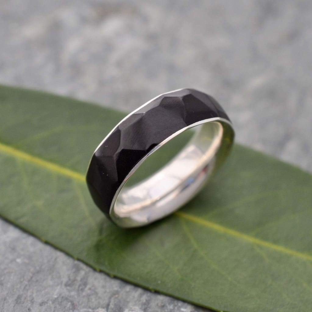 Multifaceted black coyol wood ring with recycled sterling silver interior