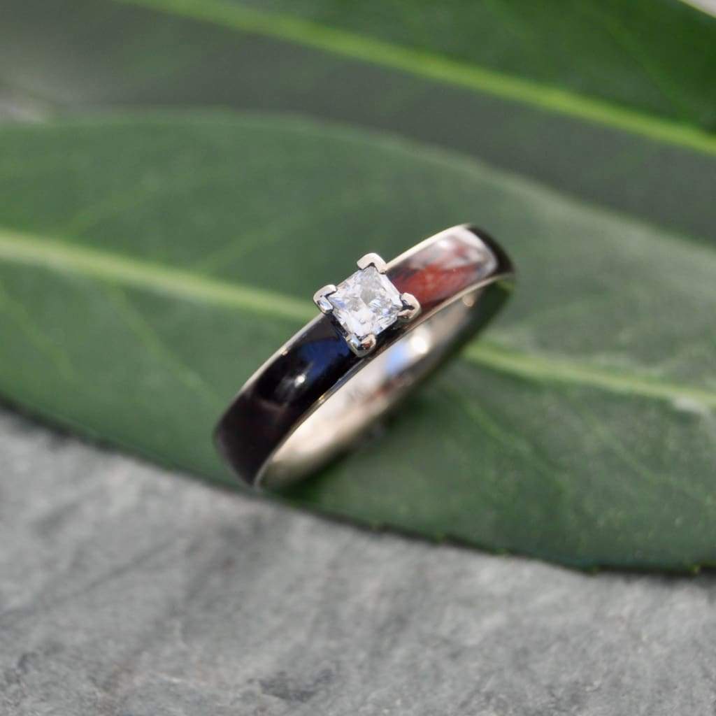Princess cut diamond wood engagement ring with koa wood and white gold worn on hand