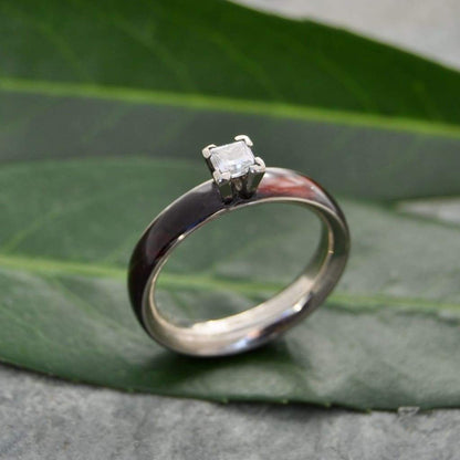 Princess cut diamond wood engagement ring with koa wood and white gold on natural background