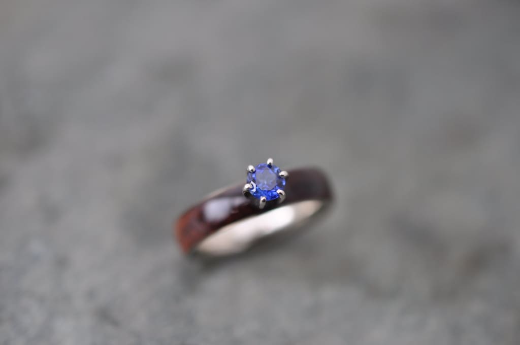 Sapphire and koa wood engagement ring with white gold close up of grain