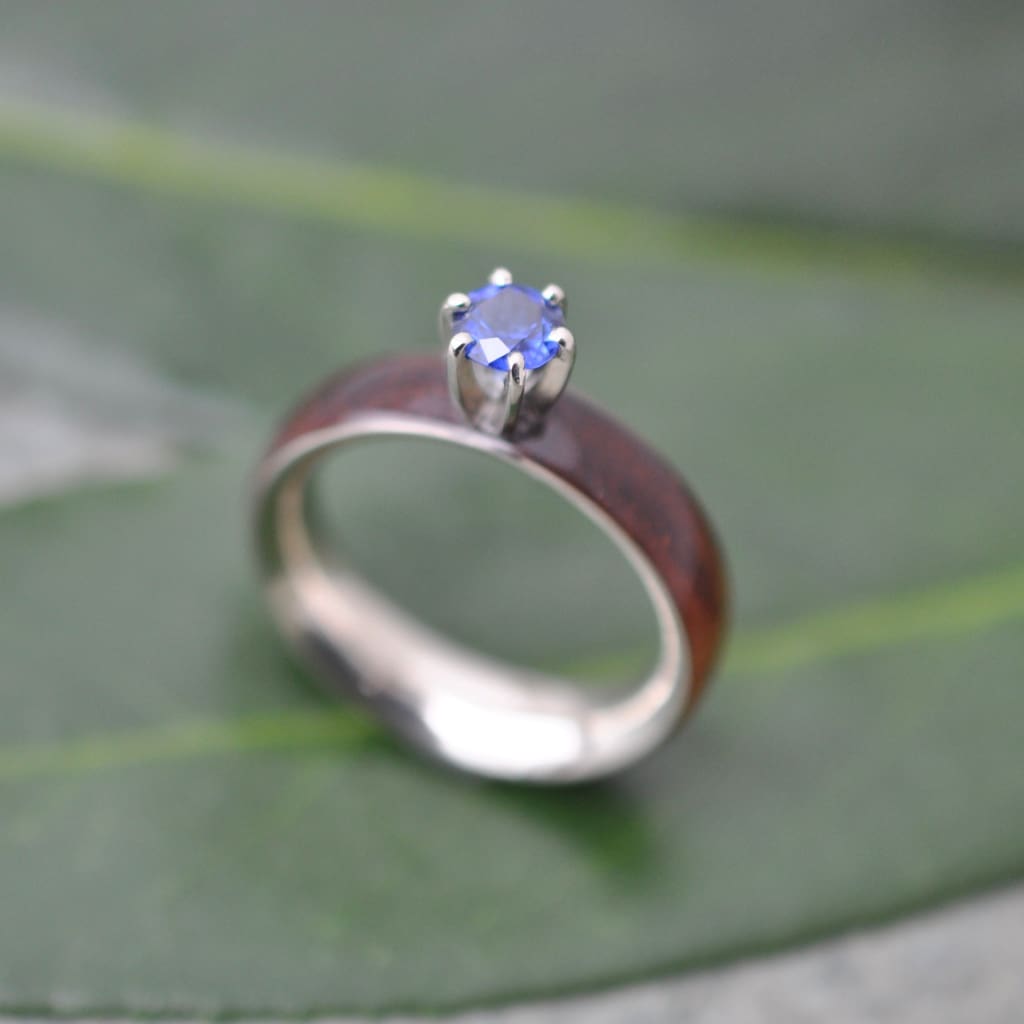 Sapphire and koa wood engagement ring with white gold worn on hand