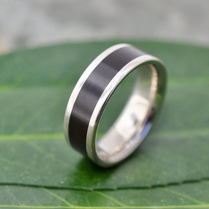 Lados Comfort Fit Lados Coyol Wood Sterling Silver Edges Wedding Ring on green leaf background, handcrafted in Louisville KY.