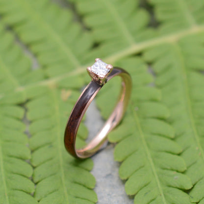 Rose gold diamond wood engagement ring with koa wood and princess cut diamond worn on hand