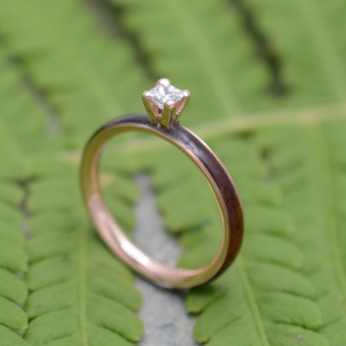 Rose gold diamond wood engagement ring with koa wood and princess cut diamond close up of grain